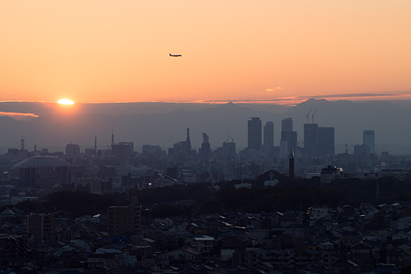 名古屋駅ビルと夕陽と飛行機